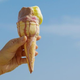 Hand holding melting ice cream cone